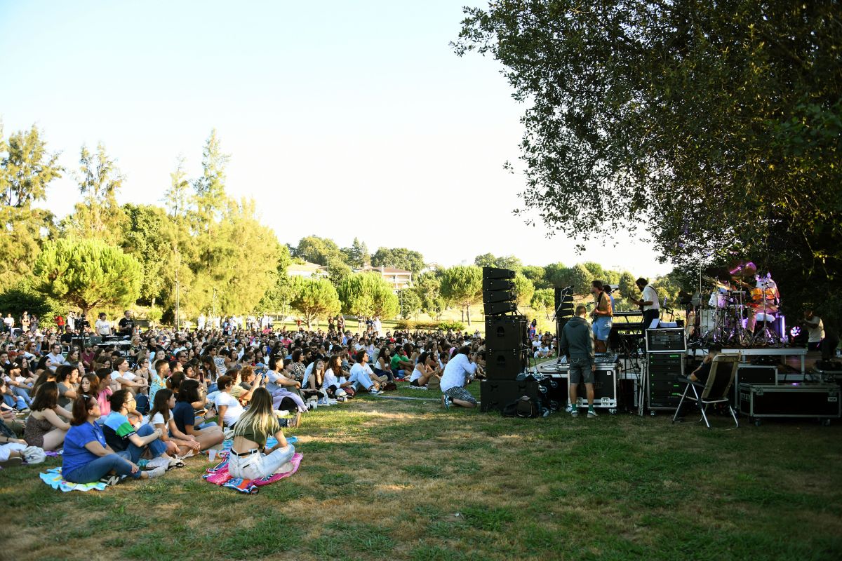 pessoas sentadas na relva do parque da Devesa para assistir a concertos musicais